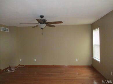 Spare room with wood finished floors and ceiling fan