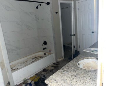 Bathroom featuring vanity and tiled shower / bath