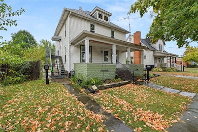 American foursquare style home featuring stairway, a porch, and a front yard