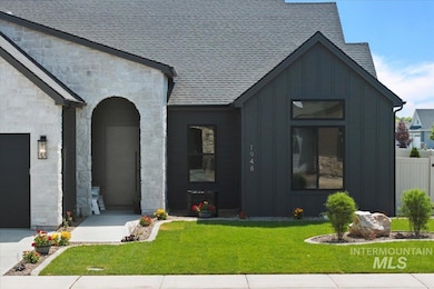 View of front of property with board and batten siding, stone siding, and a shingled roof