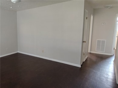 Unfurnished room featuring visible vents, baseboar