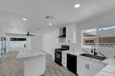 Kitchen with black appliances, wall chimney exhaus
