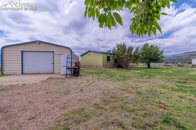 View of yard with an outdoor structure, concrete driveway, and a garage