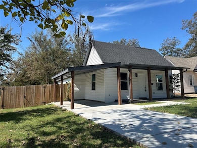 Covered porch with architectural details and convenient carport.