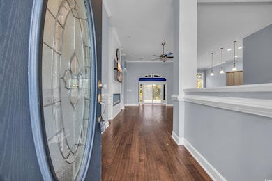 Foyer featuring a ceiling fan, dark wood finished floors, and ornamental molding