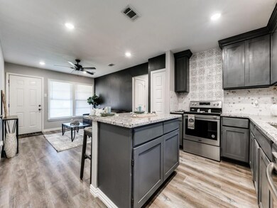 Kitchen with light stone counters, a kitchen islan