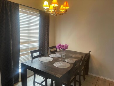 Dining room featuring a chandelier and light tile 
