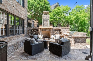 Anchoring the outdoor space is a striking stone and brick patio, complete with a cozy outdoor fireplace