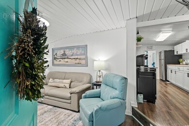 Living room with lofted ceiling with beams and har