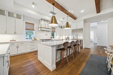 The chef's kitchen has a large quartzite island and all stainless steel appliances.