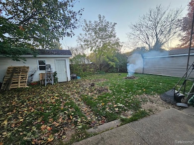 View of grassy yard featuring an outdoor structure