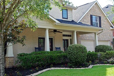 Inviting covered porch features ceiling fans and brick paver flooring.