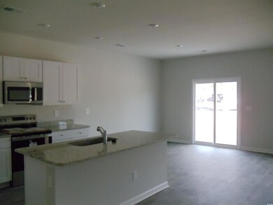 Kitchen featuring light stone counters, wood finis