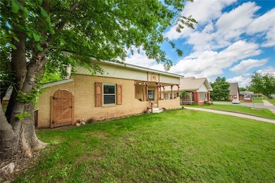 View of front of home featuring brick siding, a front lawn, and covered porch