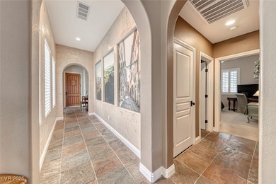 Hallway with stone tile flooring, a textured wall,