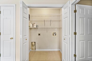 Laundry room with light tile patterned floors, ele