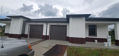 View of front of home with roof with shingles, a garage, and a porch