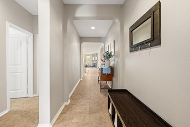 Corridor featuring arched walkways and light tile