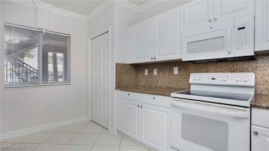 Kitchen featuring white appliances, decorative bac