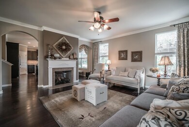 The spacious living room has a dual sided gas fireplace, open like feel from Living to Kitchen, and attractive paint colors!