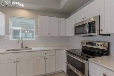 Kitchen with a sink, tasteful backsplash, applianc