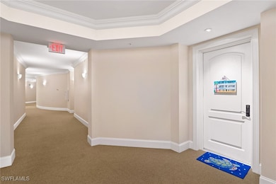 Carpeted foyer featuring baseboards, ornamental mo