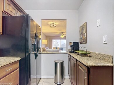 Kitchen with light tile patterned floors, black re