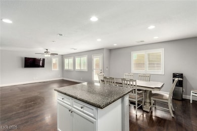 Kitchen featuring baseboards, white cabinets, dark