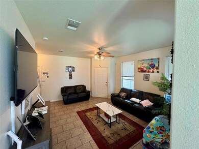 Tiled living room with a ceiling fan