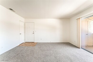 Unfurnished room featuring visible vents, light ca
