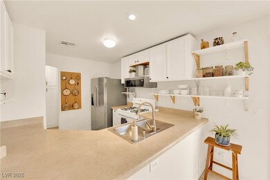 Kitchen featuring white cabinetry, light counterto