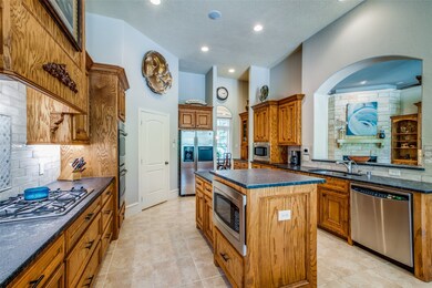 The kitchen has 2 ovens, 2 microwaves, gas cooktop and is open to the family room.