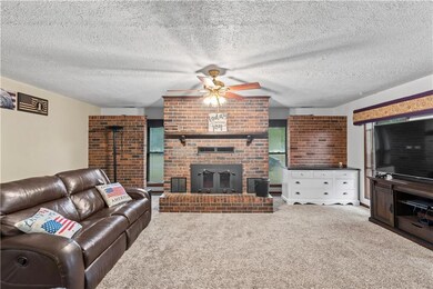 Spacious living room with tons of windows and ceiling to floor brick fireplace. 
