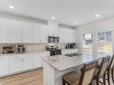 Kitchen with a kitchen island with sink, sink, whi