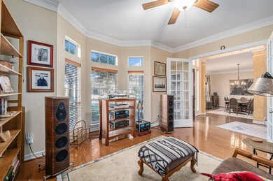 Private study boasts wood flooring, double crown molding, French doors and ceiling fan.  Shelving units are not built-ins.