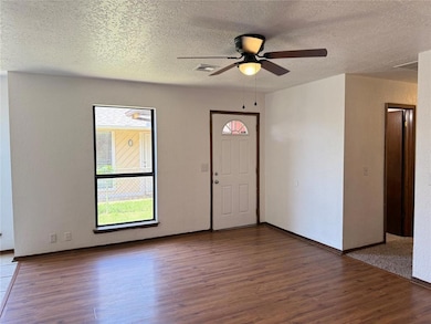 Entryway featuring a ceiling fan, wood finished floors, and a textured ceiling