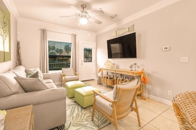 Living area featuring visible vents, baseboards, ceiling fan, tile patterned flooring, and ornamental molding