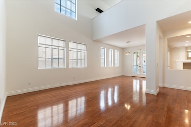 Unfurnished living room featuring french doors, ba