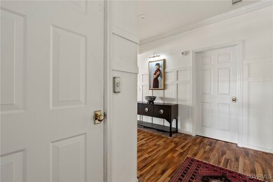 Hall with crown molding, a decorative wall, and da