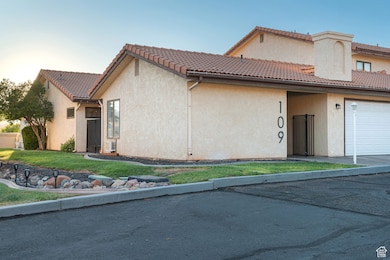 View of front of house featuring stucco siding, an attached garage, and a tile roof