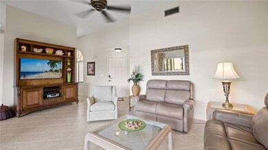 Living room featuring light tile patterned floors, a ceiling fan, and baseboards