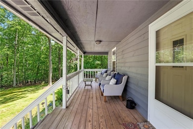 Wooden porch featuring a lawn and an outdoor living space