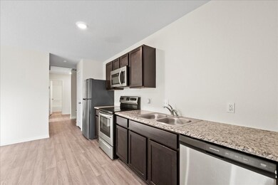 The kitchen features brown cabinets, granite count