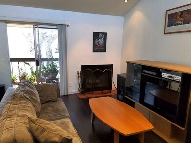 Vaulted ceiling and wood-burning fireplace in livi