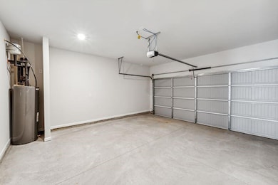 Garage featuring a garage door opener and water heater