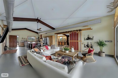 Living room with a barn door, vaulted ceiling wit
