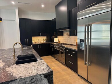 Kitchen featuring dark cabinetry, high end applia