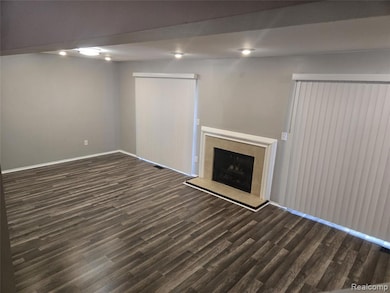 Unfurnished living room with dark wood-type flooring and a fireplace