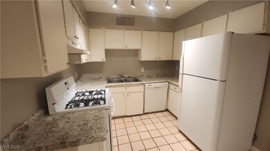 Kitchen featuring white appliances, a sink, under