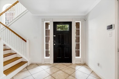 Bright and airy entry with tiled flooring, crown m